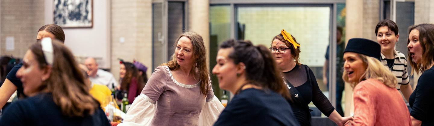 A group of women laughing and smiling while ceilidh dancing