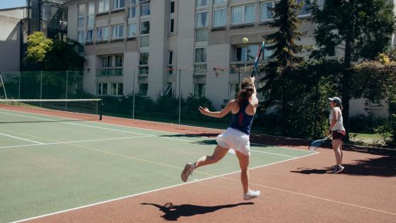 Students playing tennis in the sunshine