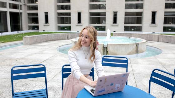 Woman sits at table using laptop