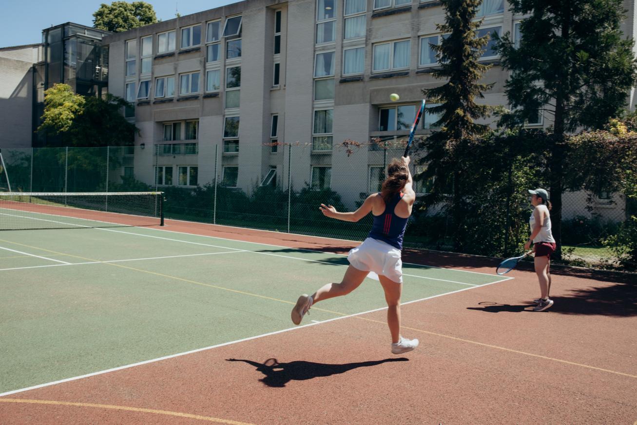 Students playing tennis in the sunshine